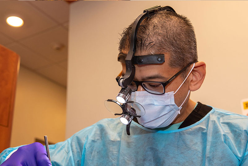 docotor performing dental procedure with patient within the dental center